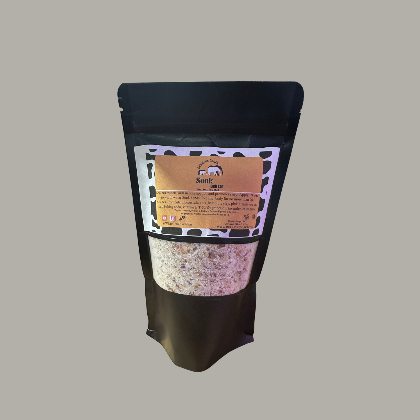 A black stand-up resealable pouch with a clear window showing a light-colored granular product inside, and a tan label on the front, photographed against a plain gray background.